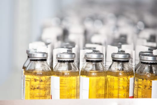 Medical closed jars with yellow liquid.