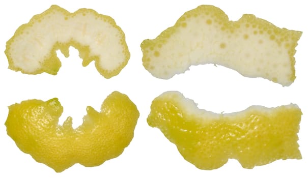 Four pieces of lemon peel in different shapes showing the white inside and yellow outside. Isolated background