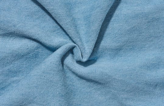 Close-up of the texture of thin light blue denim jeans