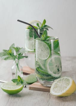 Summer drink with lime and mint. Cold drink, non-alcoholic mojito or lemonade, garnished with fresh mint sprigs and citrus slices. 
