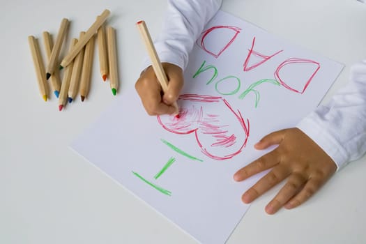 Child drawing I love you dad with colored pencils. Father day.