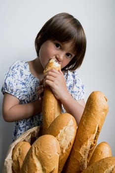 Young caucasian girl enjoying fresh french baguette against white background.