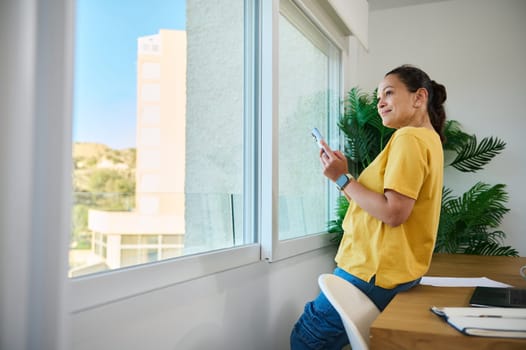 Confident entrepreneur planning projects while relaxing in a modern workspace. A tranquil scene illustrating balance between professional focus and personal comfort in a stylish home office.