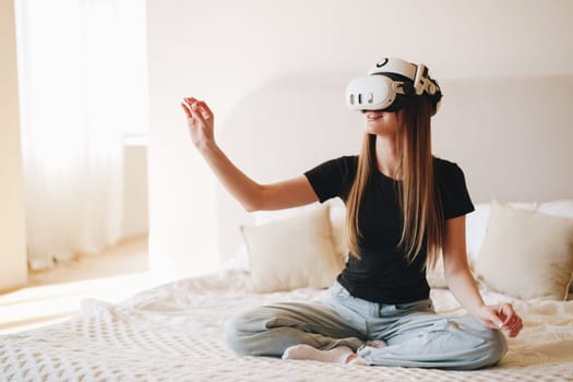 A young woman sits cross-legged on a bed, fully engaged in a virtual reality activity. Sunlight fills the room, creating a relaxing atmosphere as she interacts with digital content.