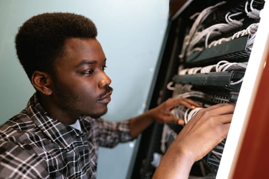 A technician meticulously organizes network cables in a server room. The workspace is bright, showcasing a commitment to detail and technical skill.