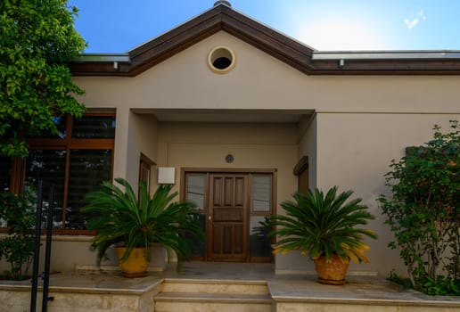 Charming entrance to a traditional house in Cyprus with stone walls, potted plants, and Mediterranean details.