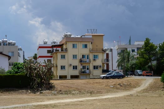 Modern three-story house with balconies and white facade, typical of Cypriot residential architecture under the Mediterranean sun.