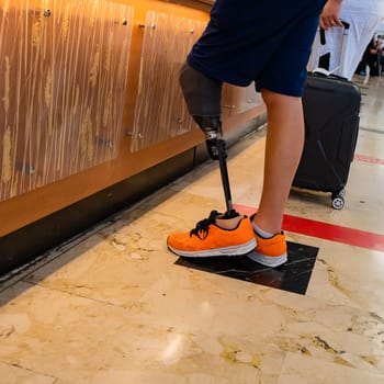 Close-up of legs of man with bionic prosthesis at airport