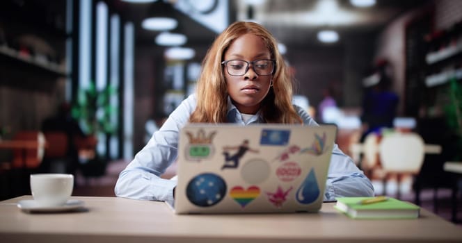 Busy African American Woman Managing Online Business At Coffee Shop