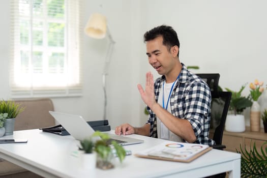 A young professional examines documents at his desk, emphasizing organization and planning in a stylish remote workspace.