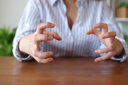 Front view close up portrait of a furious woman hands at home