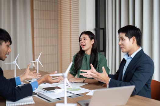 A diverse team engages in a lively discussion about ESG strategies and sustainable practices in a corporate setting.