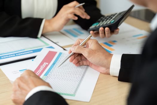 Two business professionals engaged in a discussion about financial reports, emphasizing teamwork and data analysis.