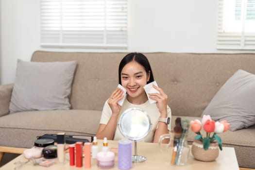 A woman prepares for her skincare routine, holding makeup wipes and smiling. The image captures the essence of self-care and beauty preparation.