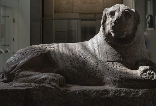 London, UK - May 31, 2025 - Red granite statue of The Prudhoe Lions or Soleb Lions from the Temple of Soleb in Nubia, Ancient Egyptian red granite monumental sculptures of recumbent lion inside of the British Museum. use it as your Wallpaper, Poster and Space for text, Selective focus.