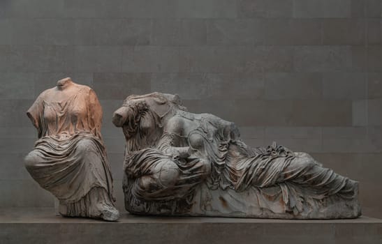 London, UK - May 31, 2025 - Cast of Aphrodite reclining in the lap of her mother Dione with Hestia, goddess of the hearth, Greek statue from east pediment of Parthenon which were made from marble inside of British Museum. use it as your Wallpaper, Poster and Space for text, Selective focus.