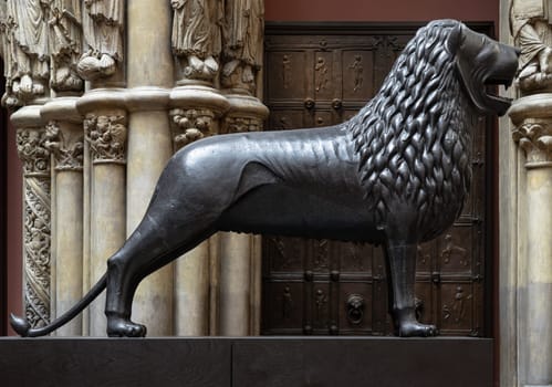 London, UK - May 07, 2025 - Side view of The Brunswick Lion Bronze Statue, is a medieval sculpture is commonly known as the "Castle Lion" (Burglowe) Displayed in The V&A (Victoria and Albert Museum) in London, use it as your Wallpaper, Poster and Space for text, Selective focus.