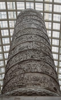 London, UK - May 07, 2025 - Looking up view Trajan's Column, a famous Roman monument. This replica, a plaster cast, is split into two halves and stands as a prominent feature at The "Eastern Cast Court" Displayed in The V&A (Victoria and Albert Museum) in London, use it as your Wallpaper, Poster and Space for text, Selective focus.