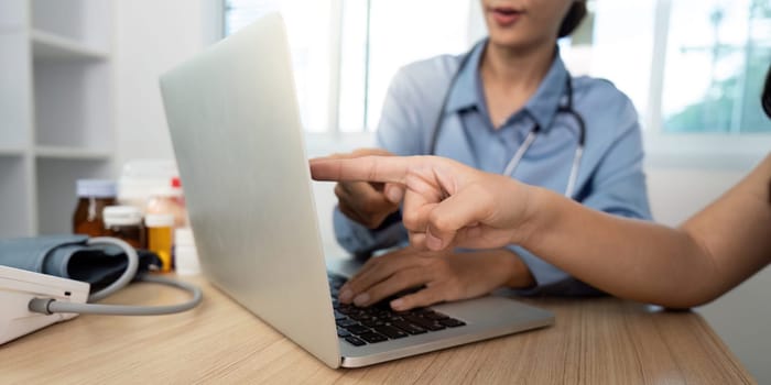 A doctor assists a patient with their health concerns via a laptop, promoting digital healthcare solutions.