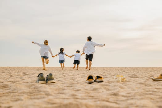 Father, mother and kids take off shoes run on sand beach, Back view of family parents with children fun holding hands together running to beach in holiday, Travel, active lifestyle, Happy family day
