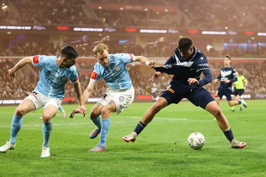 MELBOURNE, AUSTRALIA - MAY 31: Steven Ugarkovic and Nathaniel Atkinson of Melbourne City battle with Zinedine Machach of Melbourne Victory during the A-League Men Grand Final match between Melbourne City and Melbourne Victory at AAMI Park on May 31, 2025, in Melbourne, Australia.