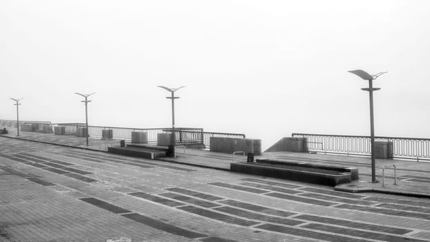 The dense mist obscures the details of the landscape, veiling the quayside in an enigmatic shroud. High quality photo