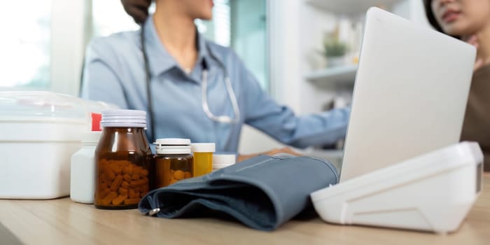 A healthcare professional engages with a patient, discussing medication options while surrounded by medical supplies and technology.