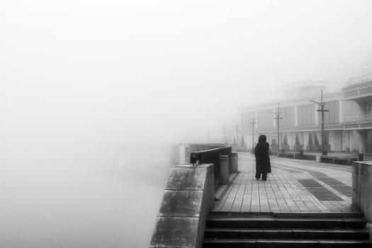 The dense mist obscures the details of the landscape, veiling the quayside in an enigmatic shroud. High quality photo