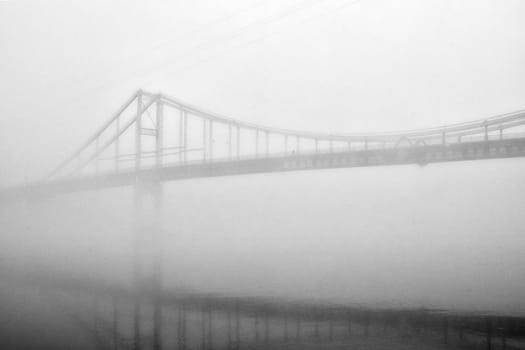 The thick fog lends an air of mystery to the scene, softening the edges of the landscape and blurring the boundaries between reality and imagination.