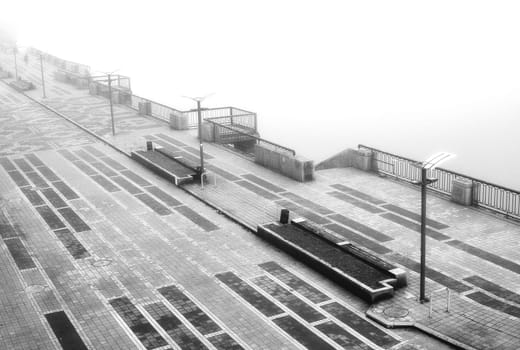 The dense mist obscures the details of the landscape, veiling the quayside in an enigmatic shroud. High quality photo