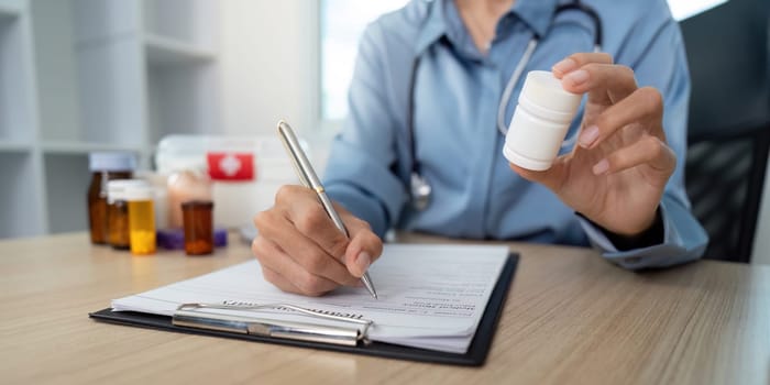 A healthcare professional documents a prescription, ensuring proper medication management in a clinical environment.