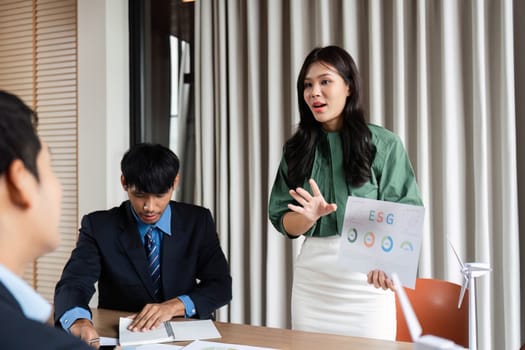 A businesswoman presents ESG data during a corporate meeting, emphasizing sustainability and governance strategies.
