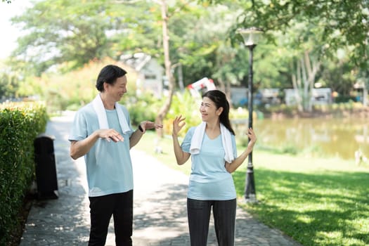 A senior couple shares a playful moment while exercising outdoors, showcasing the fun side of staying active together.