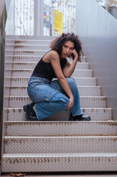 African American woman dancing in a creative pose between benches in an urban setting. he wears casual clothes and shows balance,strength, and expression. Concept of movement, art,and freedom.Vertical