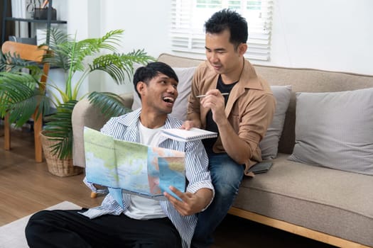Two men share joyful moments while jotting down travel plans, showcasing their excitement and creativity in planning the perfect getaway.