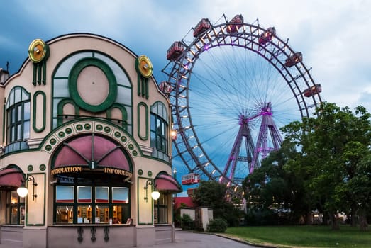 Entrance to public park in Vienna, Austria, known as Prater park and its historic Ferris wheel or Wiener Riesenrad at cloudy dusk