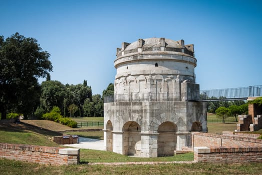 Mausoleum of Theodoric the Great, first king of Ostrogoths in Italy in 5th century, in Ravenna, Italy against clear blue sky and greenery. The building is famous for its fully stone-cut cupola and is situated in public park of the historic town.