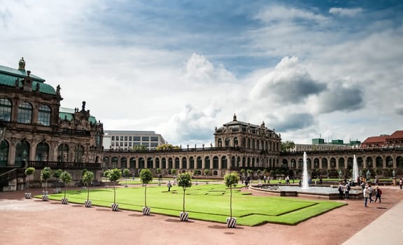 View of Zwinger square from steps of Old Masters Picture Gallery, Dresden, Saxony, Germany. Great clouds in blue sky, famous picture gallery with world-scale masterpieces, heavily ruined in WWII and then restored.