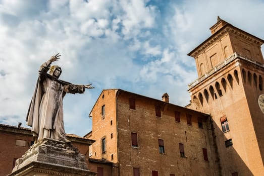 Monument to Girolamo Savonarola, famous monk and reformer, overlooking caste of Este family or Castello Estense in Ferrara, Italy