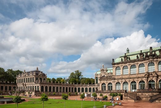 View of Zwinger square from steps of Old Masters Picture Gallery towards French and Rampant pavilions, Sep 10, 2017 - Dresden, Saxony, Germany. Great clouds in blue sky. Famous picture gallery with world-scale masterpieces, heavily ruined in WWII
