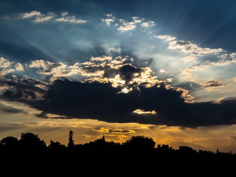 Dramatic sky with clouds on sunset and city silhouette in bottom