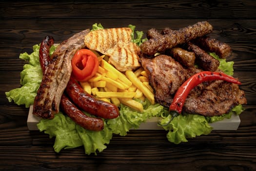 Wooden plate with various chicken and pork meat dishes placed on salads
