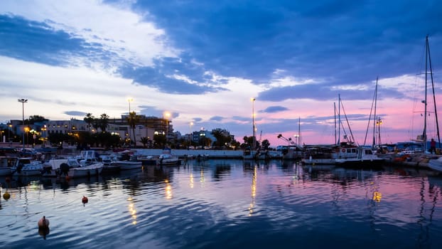 Beautiful view of Corinth port with boats, yachts and piers at sunset. Tourist destination of Ancient Corinth is close to modern port and its calm marina.