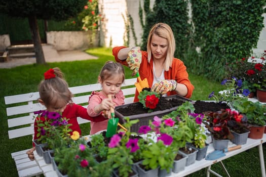Children and a parent enjoy gardening together outdoors.