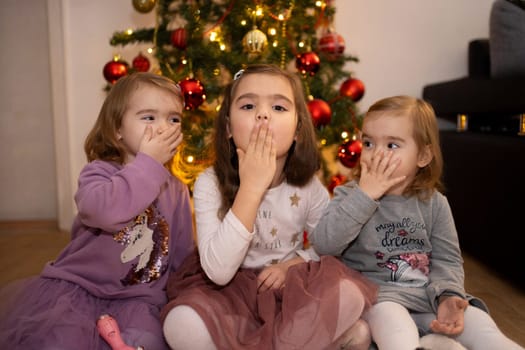Three children are having fun together, making playful gestures.