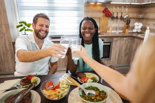 Friends enjoy a cheerful toast while sharing a delightful meal together.