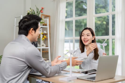 Two professionals engage in a consultation about renewable energy solutions, focusing on ESG strategies in a bright office setting.