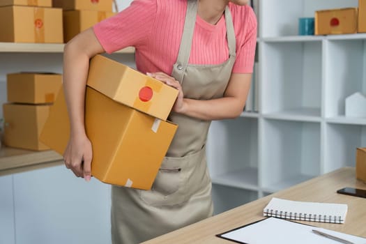 A focused entrepreneur transports packages while managing her small business, highlighting the physical aspect of logistics.