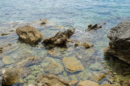 Beautiful rocks and bright turquoise water among layered rocks near Budva, Montenegro. Tropical summer landscape exotic beach on the Adriatic Sea. Vacation holiday idea