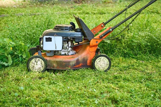 a handle electric or gasoline machine for cutting the grass on a lawn